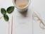 gold framed eyeglasses beside cup and notebook