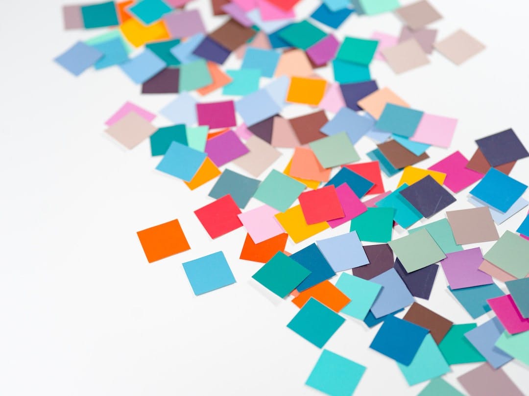a pile of multicolored confetti sitting on top of a white table