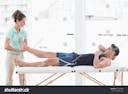 stock-photo-doctor-examining-man-leg-in-medical-office-261634685.jpg