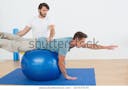 physical-therapist-assisting-young-man-600w-167537570.jpg