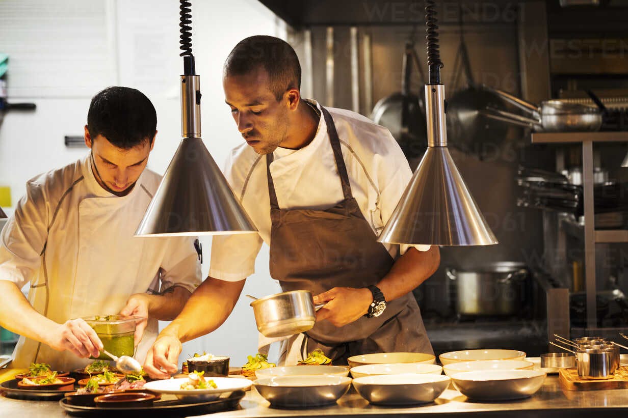 two-chefs-standing-in-a-restaurant-kitchen-plating-food-MINF03816.jpg