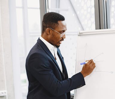 african-man-black-suit-writing-board-guy-presentation-crop.jpg