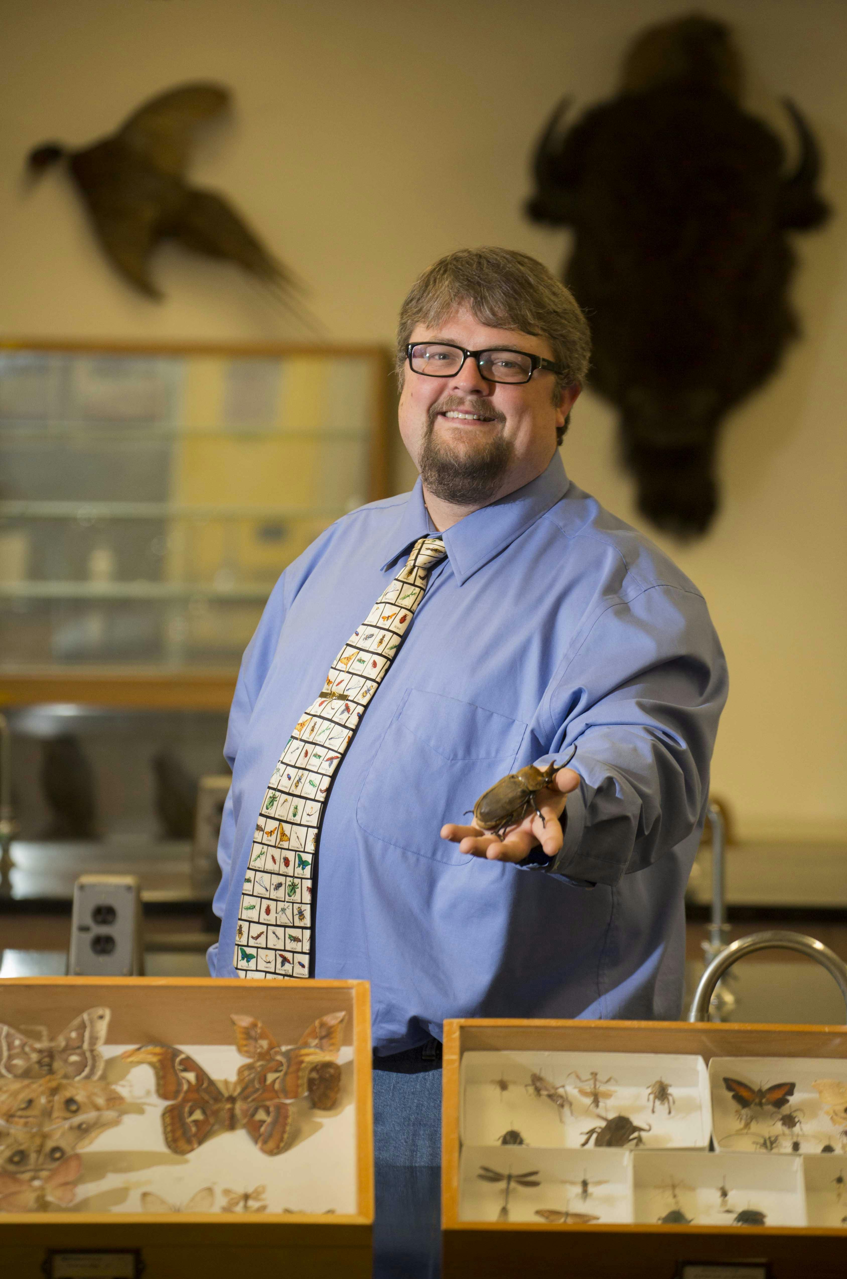 Sean in the lab holding a Dynastic beetle. 