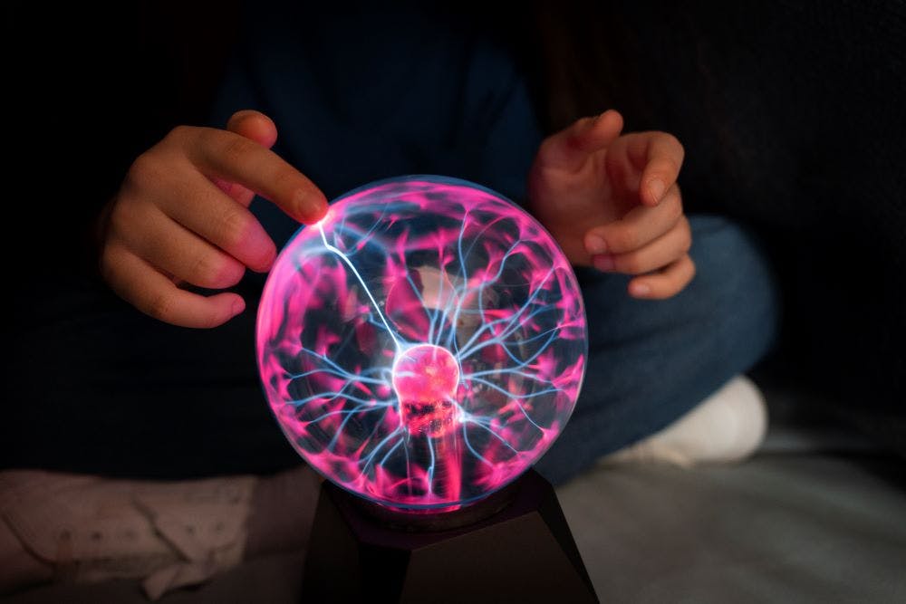 front-view-girl-interacting-with-plasma-ball.jpg