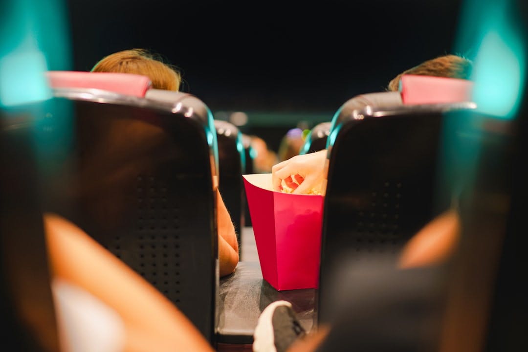 a person sitting in a chair with a red bag of food