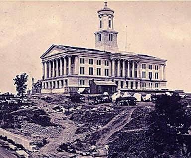 The Tennessee State Capitol, a large rectangular building with with a tower in the center, has it appeared in 1864.