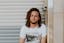 man sitting near gray steel roller shutters during daytime