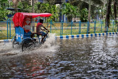 a man riding a motorcycle through water