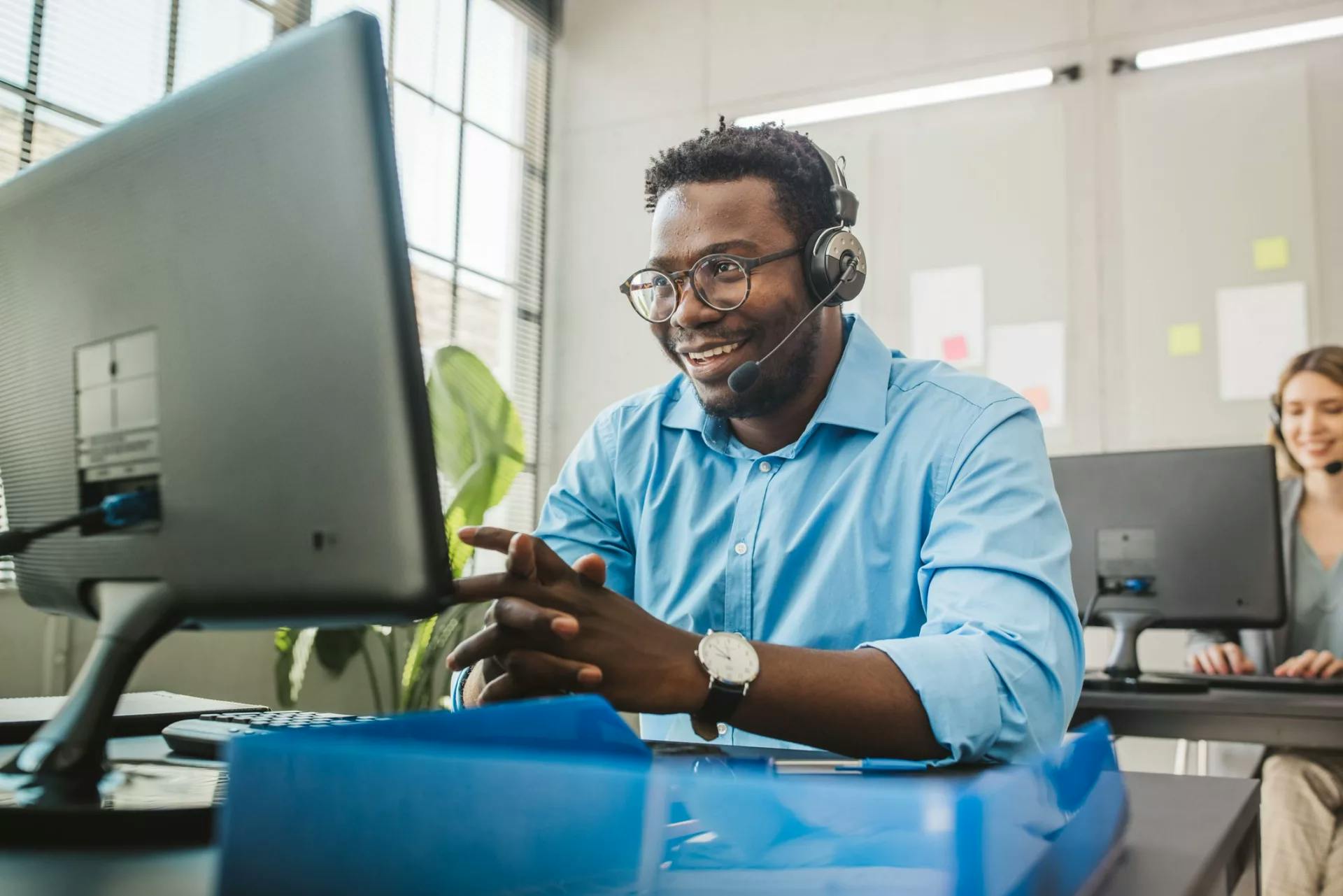Customer-Service-Agent-in-Blue-Shirt-in-Front-of-Monitor-scaled-1.webp