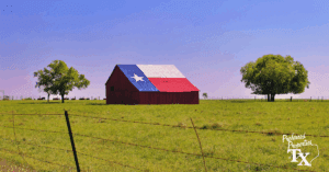 Texas barn painted with the Lone Star flag in a green pasture, framed by trees and barbed wire fence; photo for Preferred Properties of Texas, real estate experts with 30+ years in residential, land, ranch, farm, and commercial sales — contact 254-965-7775 or pptxinfo@preferredpropertiestx.com