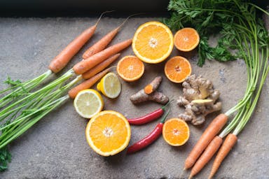 sliced orange fruit beside green and orange vegetable