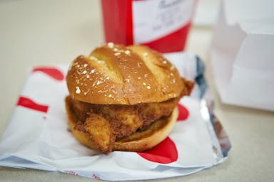 a chicken sandwich sitting on top of a piece of paper