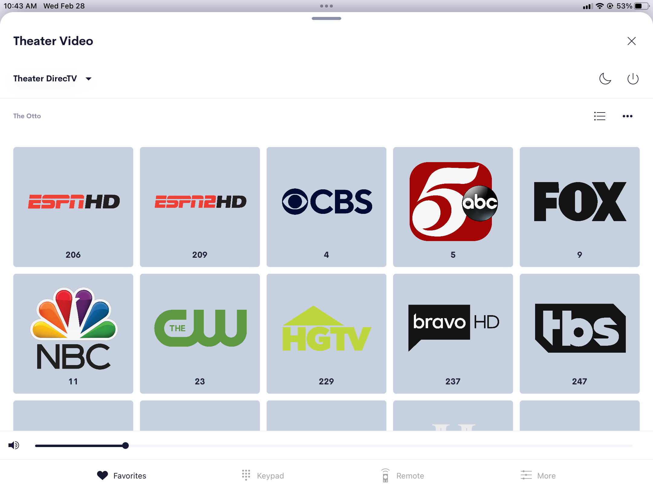 Image of a control touchscreen showing Theater DirecTV near the upper left. The screen shows a grid of channels. Near the bottom is a volume slider, and tabs for Favorites, Keypad, Remote, and More.